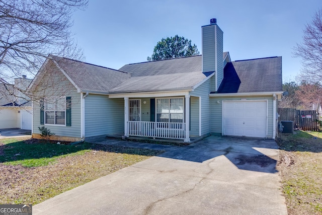 ranch-style home with a porch, an attached garage, cooling unit, concrete driveway, and a chimney