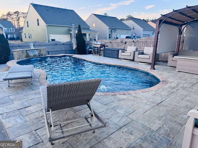 pool at dusk featuring a patio area and pool water feature