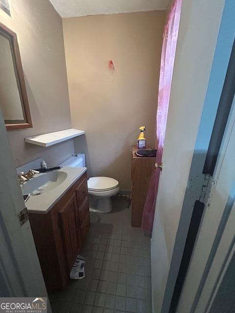 bathroom with tile patterned floors, vanity, and toilet