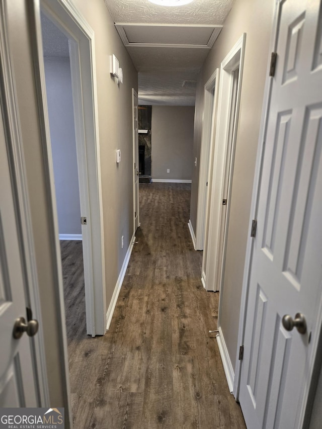 hallway featuring dark wood-type flooring and a textured ceiling