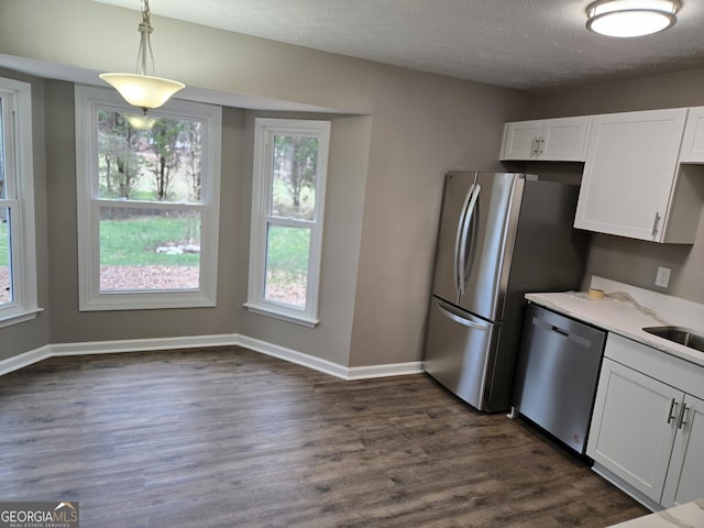 kitchen with stainless steel appliances, hanging light fixtures, white cabinets, and dark hardwood / wood-style flooring