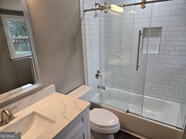 full bathroom with bath / shower combo with glass door, vanity, and toilet