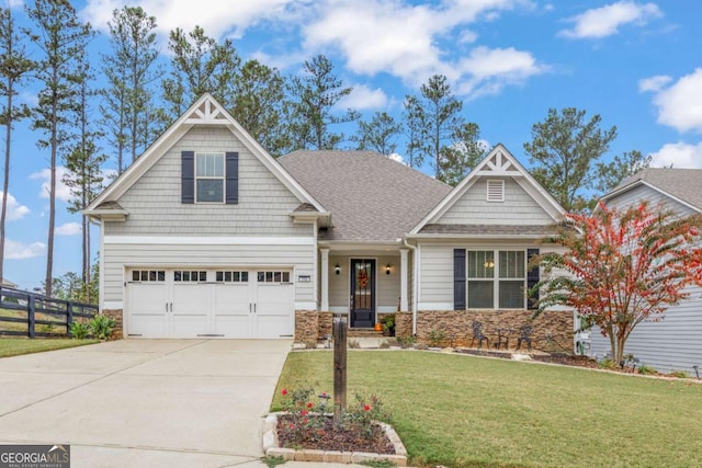 craftsman house with a garage and a front lawn