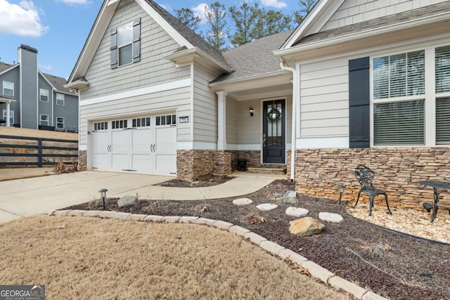 773 Riverwalk Manor Dr, Dallas, GA 30132 - craftsman-style house featuring driveway, an attached garage, stone siding, and a shingled roof