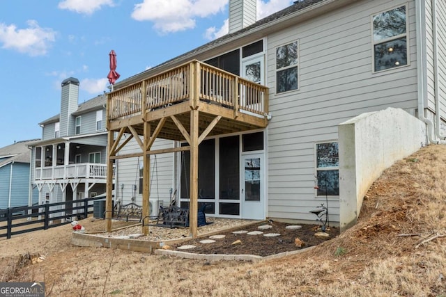 rear view of property featuring a wooden deck and central AC