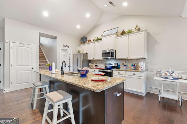 kitchen with sink, an island with sink, white cabinets, and appliances with stainless steel finishes