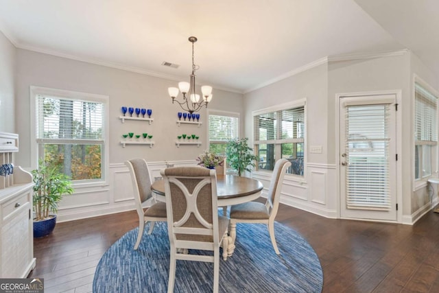 773 Riverwalk Manor Dr, Dallas, GA 30132 - dining room featuring dark wood-type flooring, a chandelier, a wainscoted wall, ornamental molding, and a decorative wall