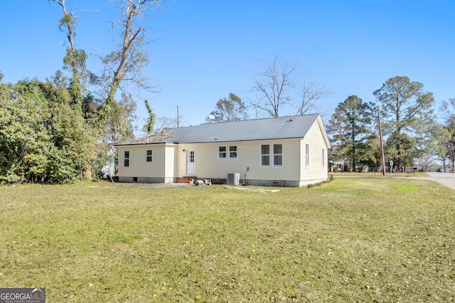 back of property with cooling unit and a yard