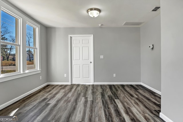 unfurnished room with dark hardwood / wood-style floors