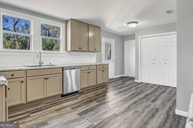 kitchen with tasteful backsplash, sink, stainless steel dishwasher, light stone counters, and light wood-type flooring