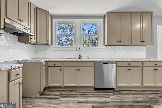 kitchen with dishwasher, sink, light stone countertops, and light wood-type flooring