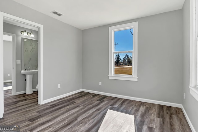 unfurnished room featuring dark hardwood / wood-style floors and sink