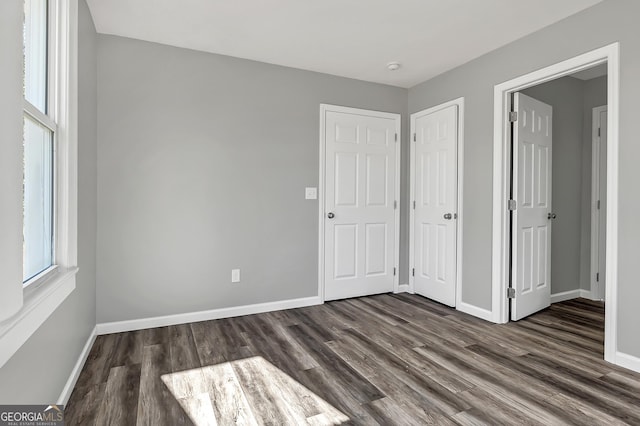 unfurnished bedroom with dark hardwood / wood-style flooring