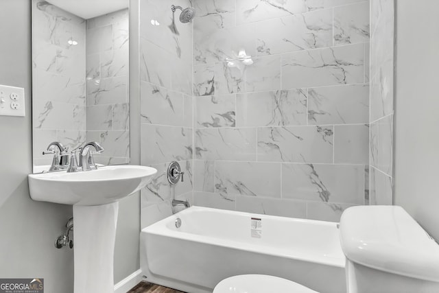 bathroom with tiled shower / bath and toilet