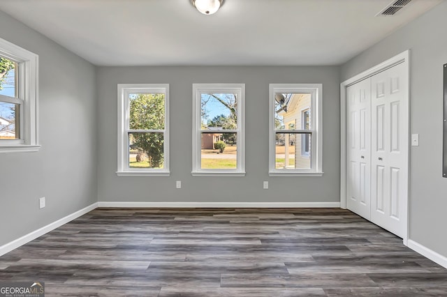 unfurnished bedroom featuring dark hardwood / wood-style floors and a closet