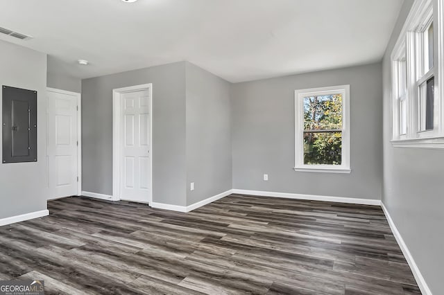 unfurnished room with dark hardwood / wood-style flooring and electric panel