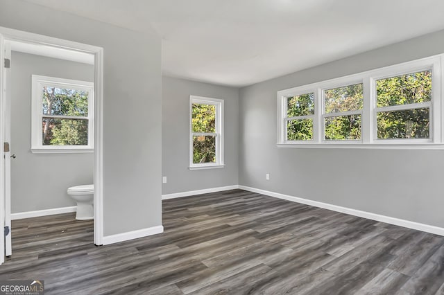 unfurnished bedroom with dark wood-type flooring and ensuite bathroom