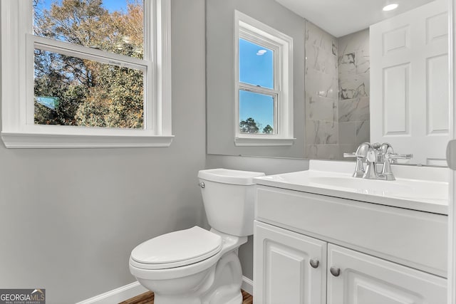 bathroom with vanity, toilet, and a wealth of natural light