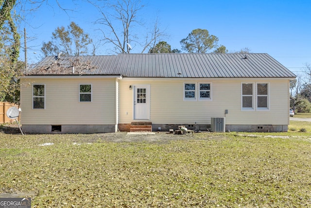 back of property with a lawn and central air condition unit