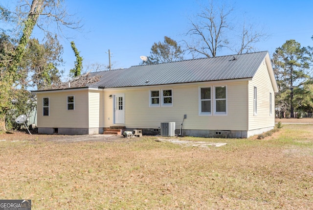 back of property with central AC unit and a lawn