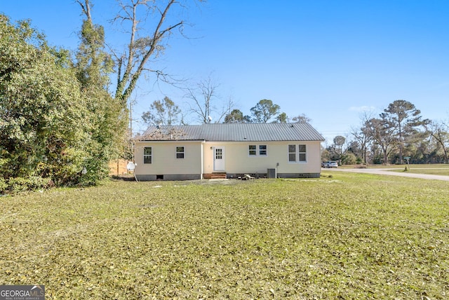 rear view of property featuring a lawn