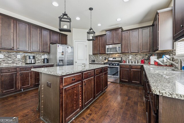 kitchen featuring dark hardwood / wood-style floors, sink, decorative backsplash, stainless steel appliances, and light stone countertops