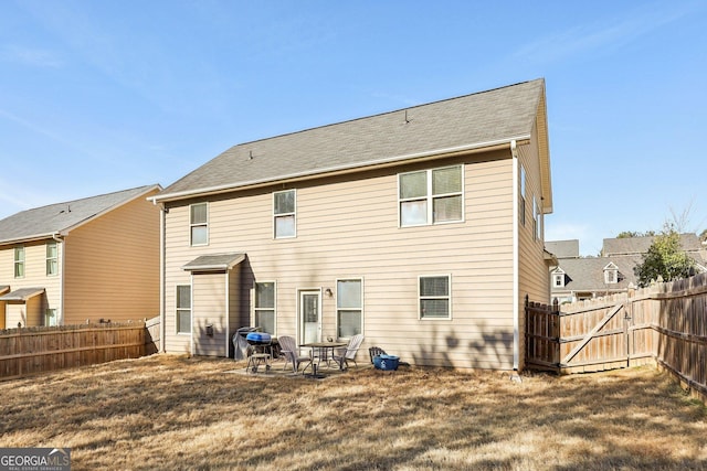 back of house with a patio area and a lawn