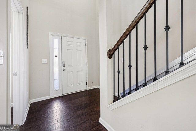 entryway featuring a towering ceiling and dark hardwood / wood-style floors