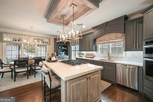 kitchen with sink, a center island, appliances with stainless steel finishes, dark hardwood / wood-style flooring, and a raised ceiling