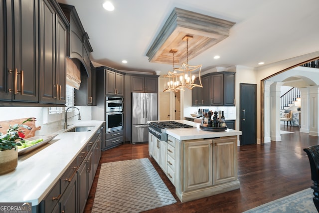 kitchen featuring appliances with stainless steel finishes, dark hardwood / wood-style flooring, a center island, and sink