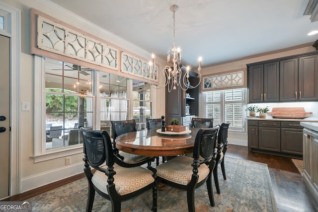 dining area featuring crown molding, dark hardwood / wood-style flooring, and an inviting chandelier