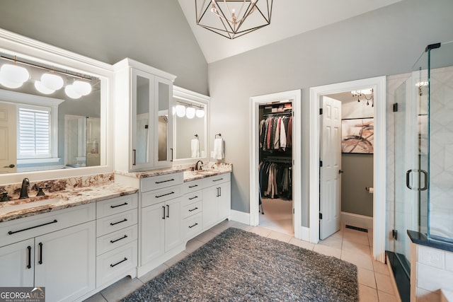 bathroom featuring vanity, an enclosed shower, tile patterned flooring, and vaulted ceiling