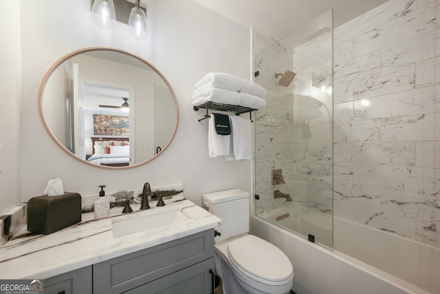 full bathroom with tiled shower / bath, vanity, and toilet