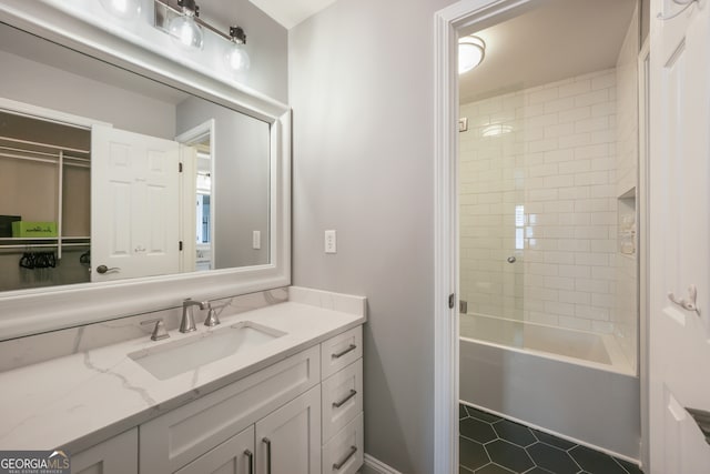 bathroom featuring tile patterned flooring, vanity, and tiled shower / bath combo