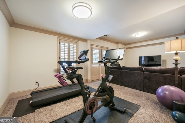 workout area with ornamental molding and carpet