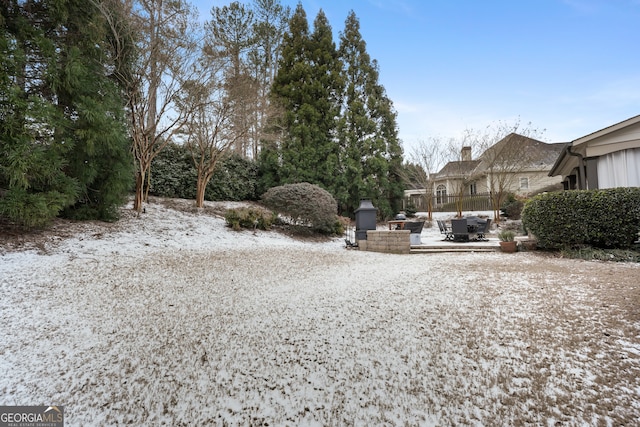 yard layered in snow with an outdoor fireplace