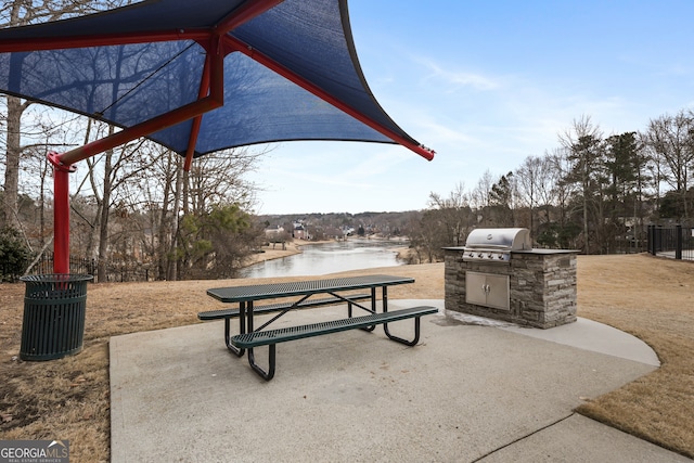 view of patio / terrace featuring a grill, a water view, and area for grilling