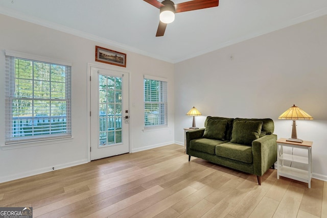 living area featuring ornamental molding, ceiling fan, and light wood-type flooring