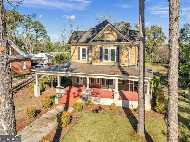 view of front of home with covered porch and a front lawn