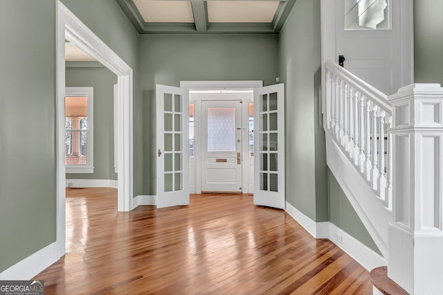 entryway with beam ceiling and light hardwood / wood-style flooring