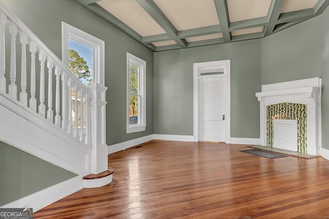 unfurnished living room with coffered ceiling, hardwood / wood-style floors, and beam ceiling