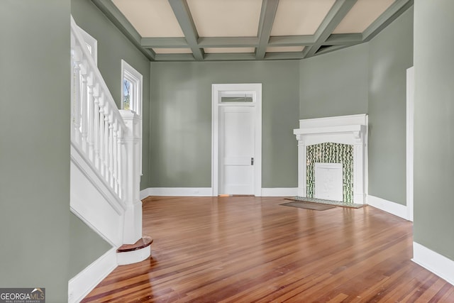 unfurnished living room featuring coffered ceiling, hardwood / wood-style floors, and beam ceiling