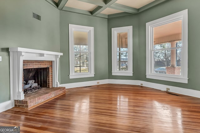 unfurnished living room with beamed ceiling, hardwood / wood-style flooring, coffered ceiling, and a fireplace