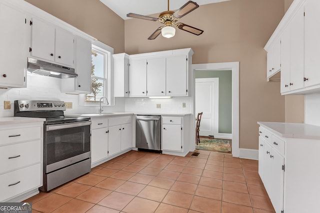 kitchen featuring light tile patterned flooring, tasteful backsplash, ceiling fan, stainless steel appliances, and white cabinets