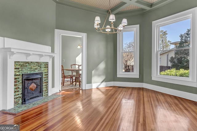 unfurnished dining area featuring coffered ceiling, wood-type flooring, beamed ceiling, and an inviting chandelier