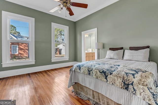 bedroom featuring ceiling fan, wood-type flooring, and ensuite bath