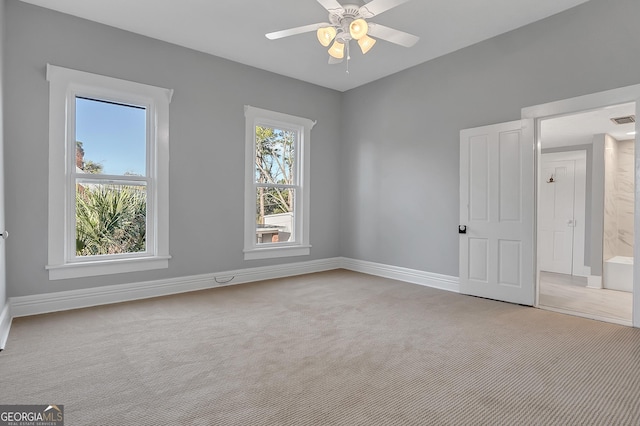 carpeted spare room featuring ceiling fan