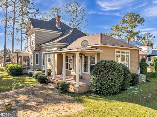 view of front of property with a sunroom, a patio area, and a front lawn