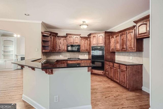 kitchen featuring black appliances, a breakfast bar area, light hardwood / wood-style floors, kitchen peninsula, and crown molding