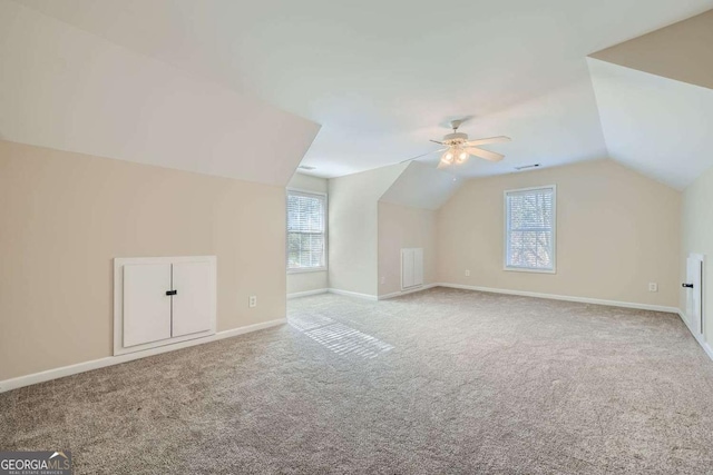 additional living space with light carpet, vaulted ceiling, and ceiling fan